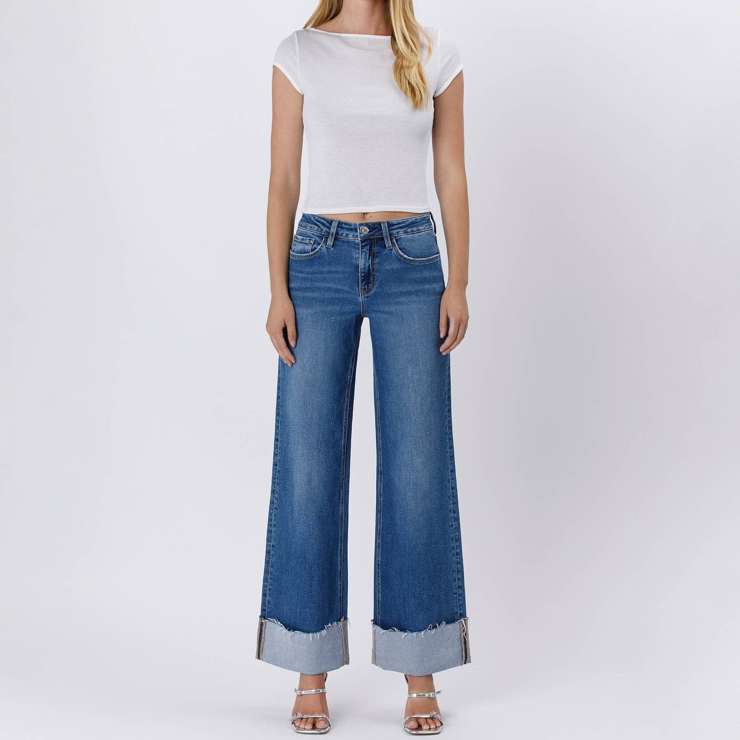 Woman in white top and wide-leg jeans.