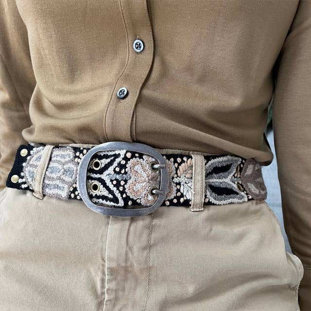 Embroidered belt with large silver buckle.