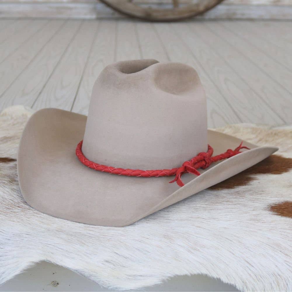 Tan cowboy hat with red band.