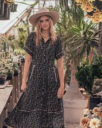 Woman in floral dress and hat in a greenhouse