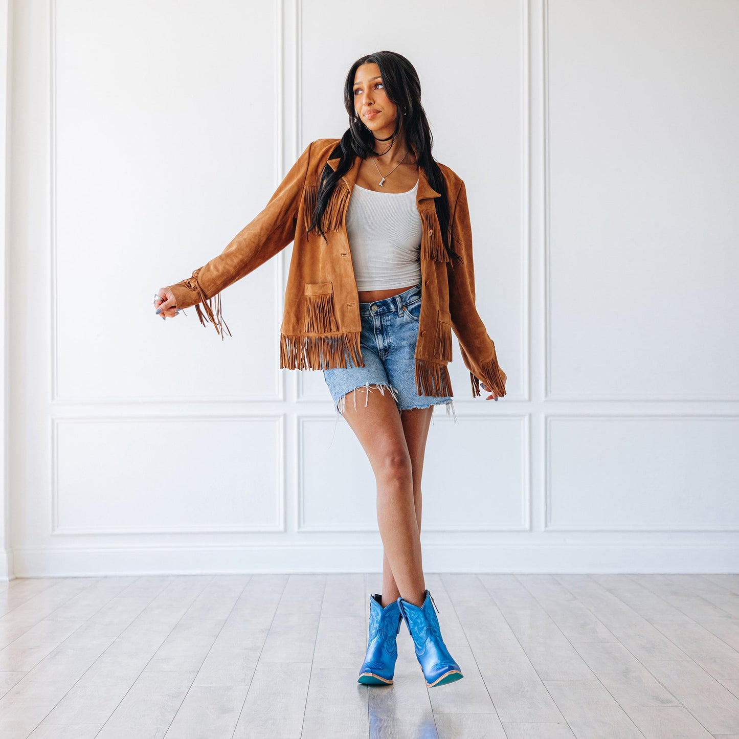 Woman in Smokeshow Bootie metallic cobalt boots and fringe jacket