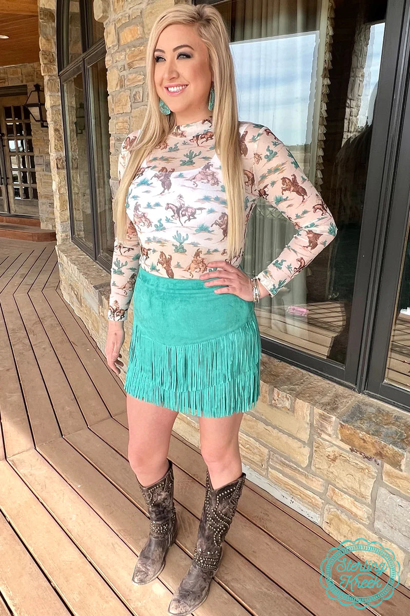 Woman in turquoise fringe skirt and cowboy top