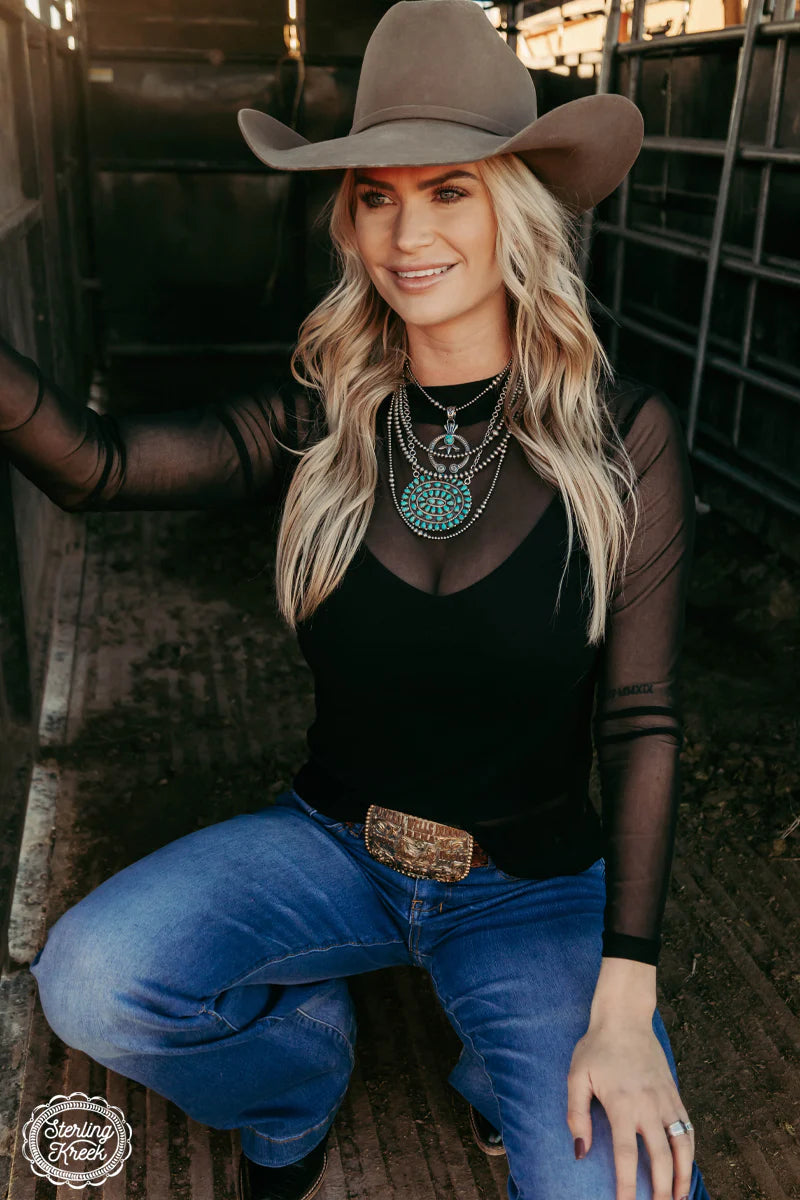 Woman in cowboy hat and jeans, solidmesh top