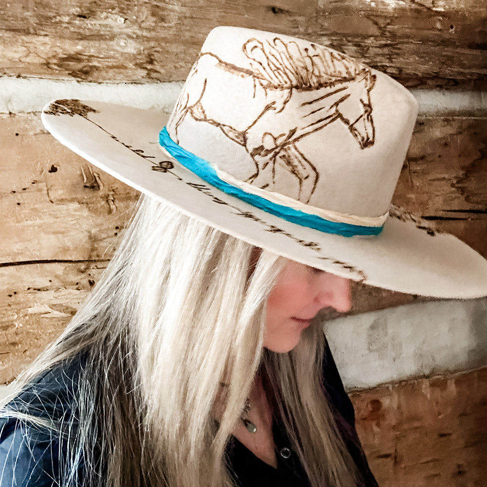 Tan hat with horse design and woman's hair