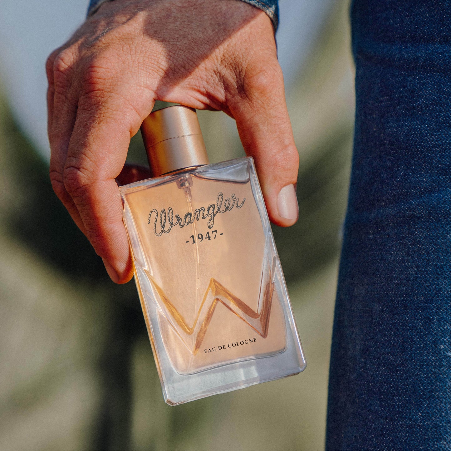 Wrangler 1947 cologne bottle held by person