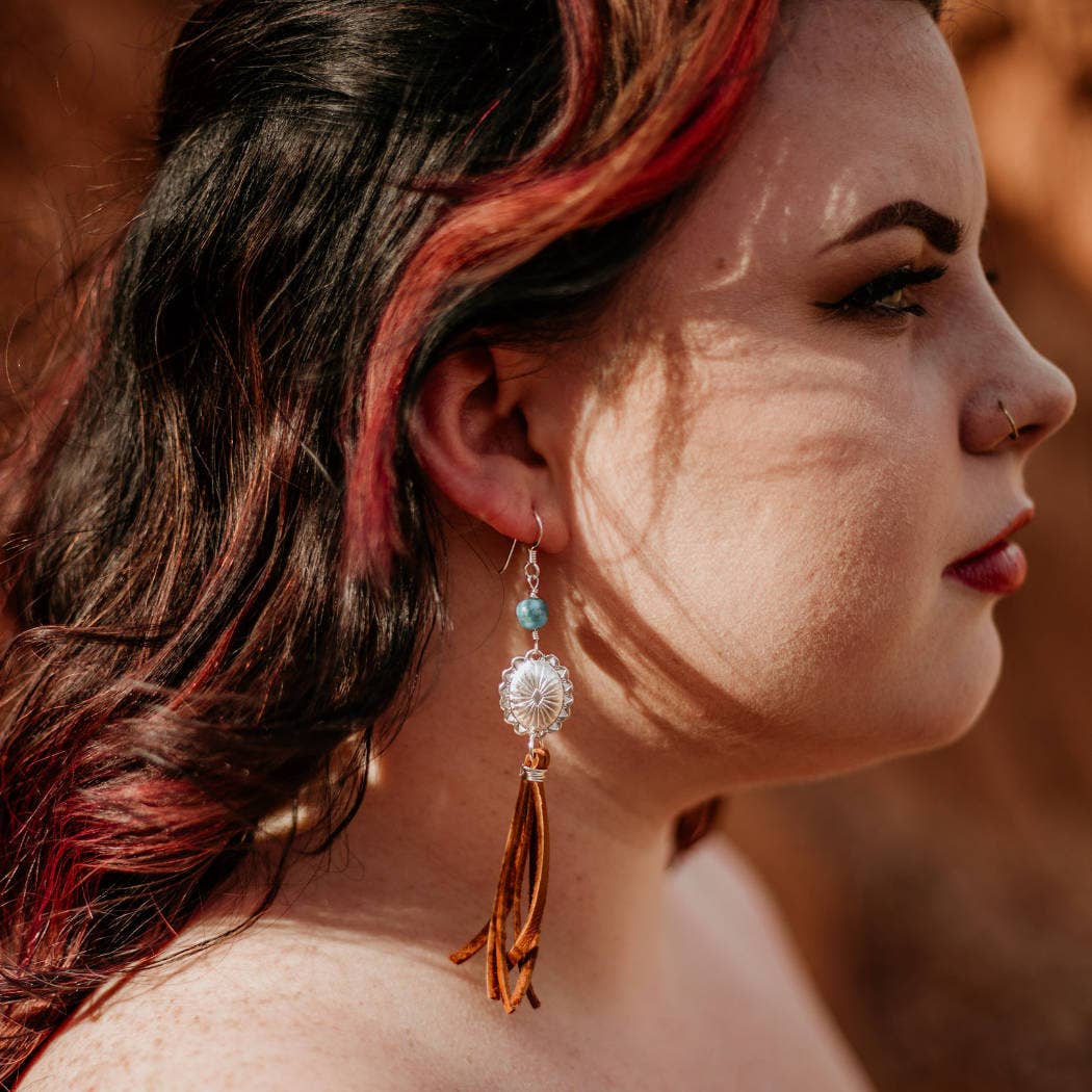 Woman wearing long earrings, looking right.