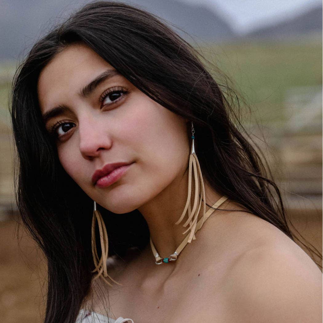 Woman with long dark hair and earrings.