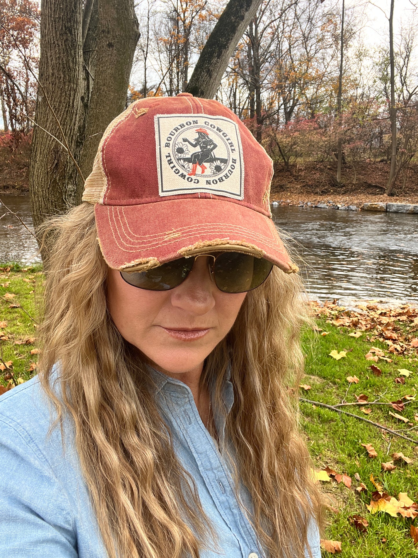 Woman wearing sunglasses and a red cap.
