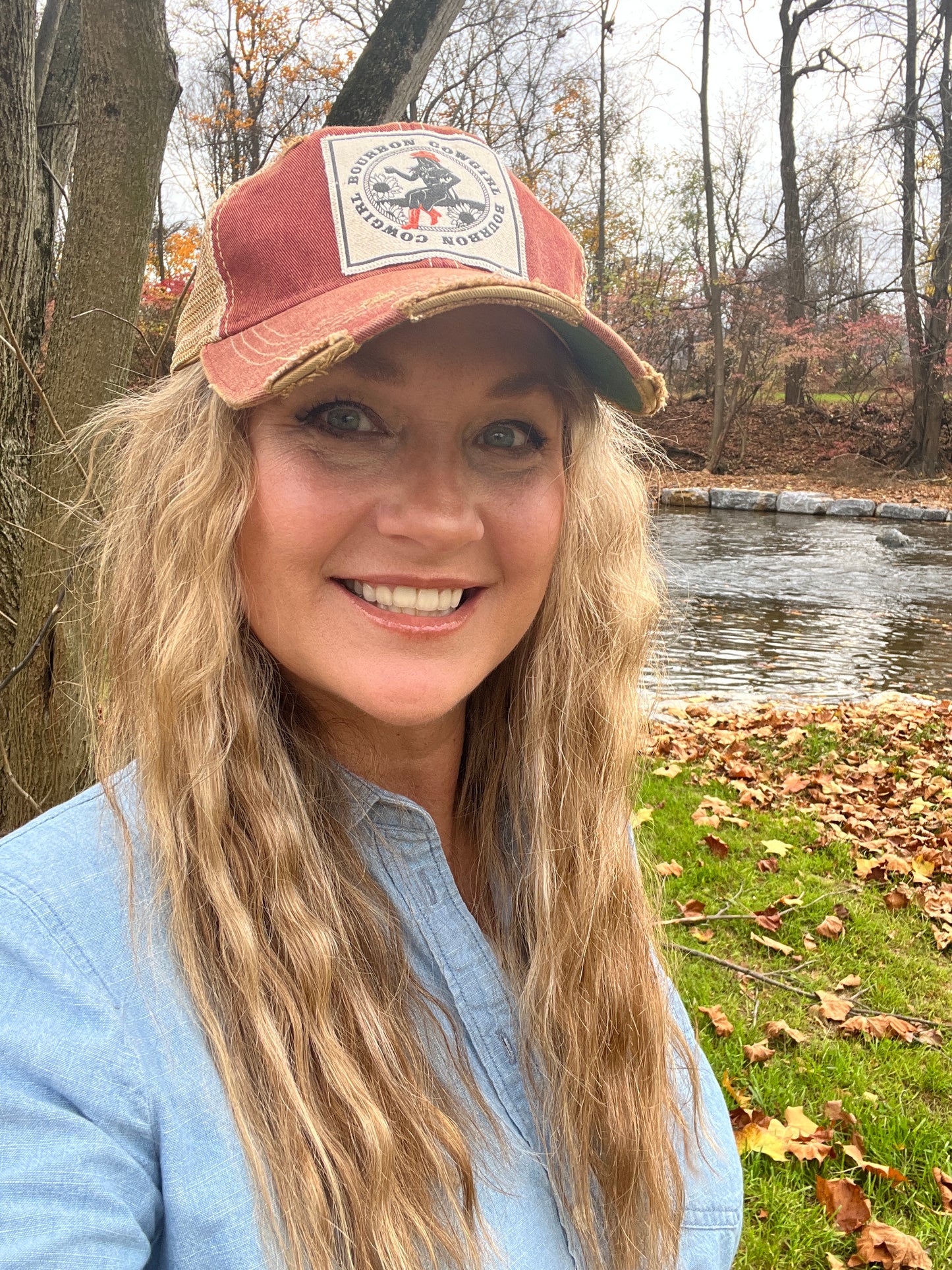 Woman wearing a red cap, smiling, outdoors.