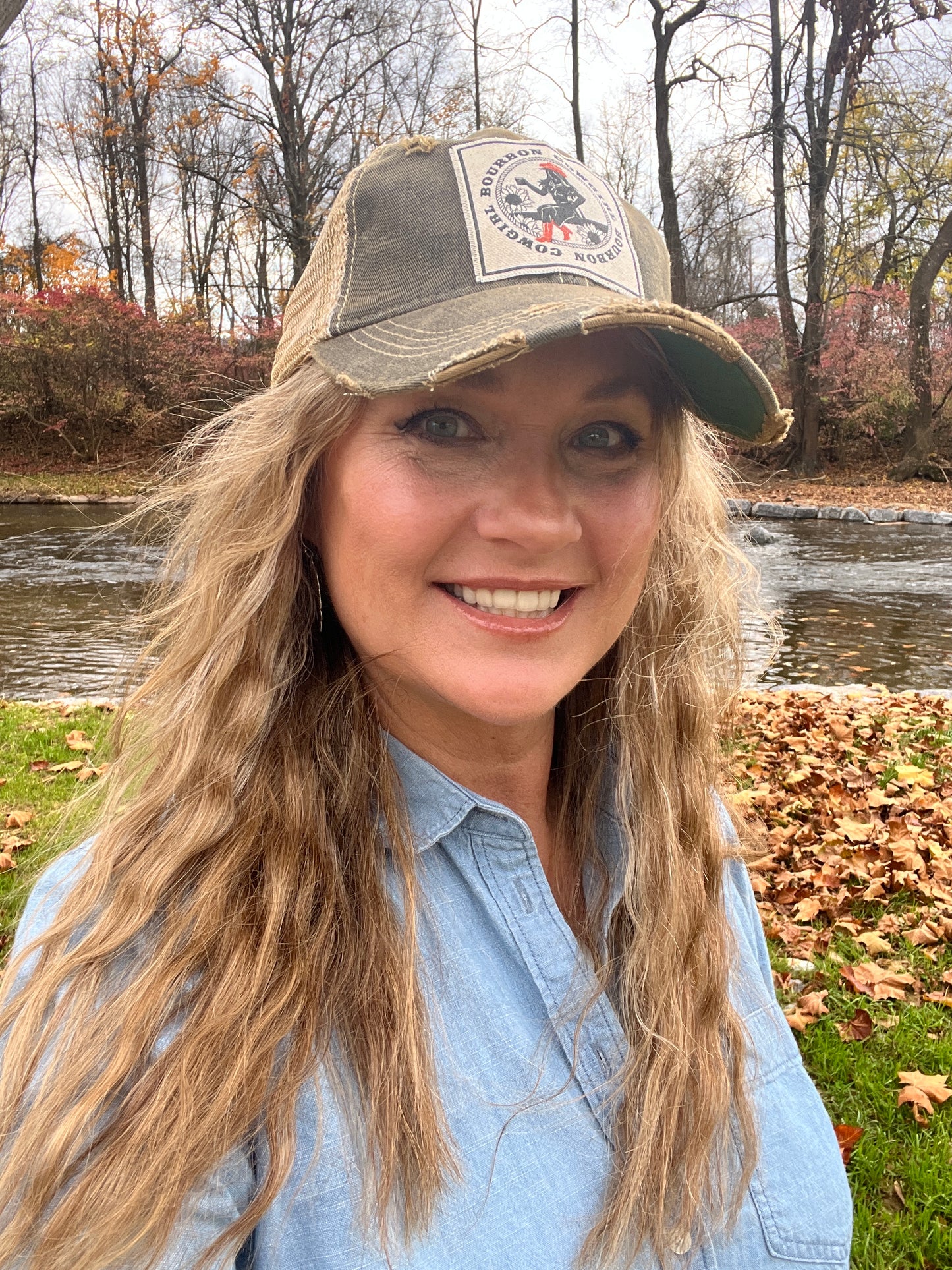 Woman in hat smiling outdoors.