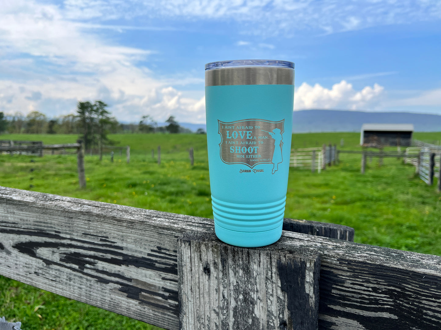 Blue tumbler on wooden fence.