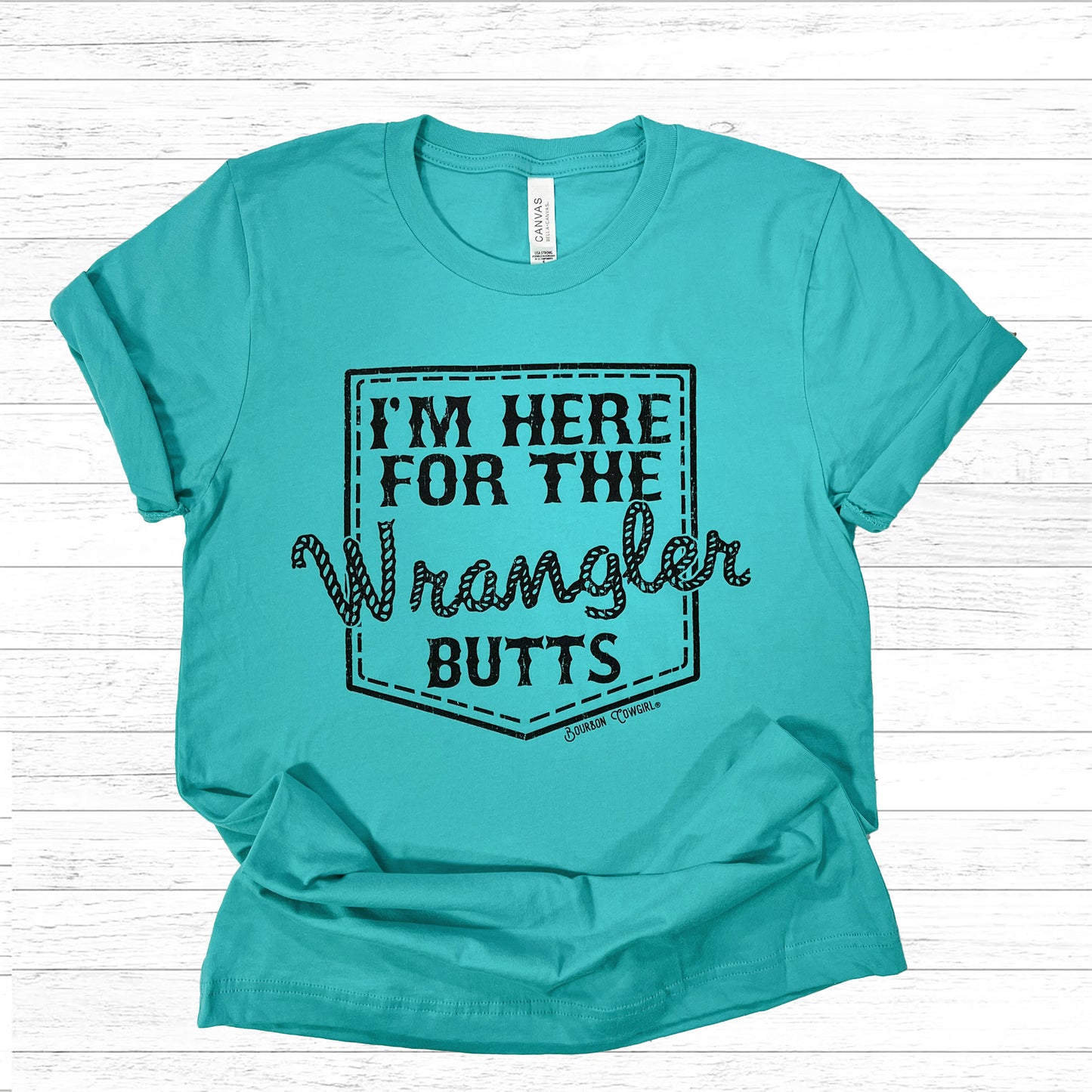 Teal I'm Here For The Wrangler Butts shirt on beadboard