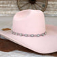 Pink cowboy hat with decorative band.