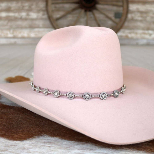Pink cowboy hat with decorative band.