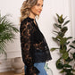 Woman in black lace top and blue jeans.