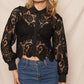 Woman wearing black lace shirt and jeans.