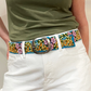 Woman wearing a floral embroidered belt with white shorts.