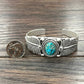 Silver cuff bracelet with turquoise stone and coin.