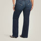 Woman wearing dark wash jeans.