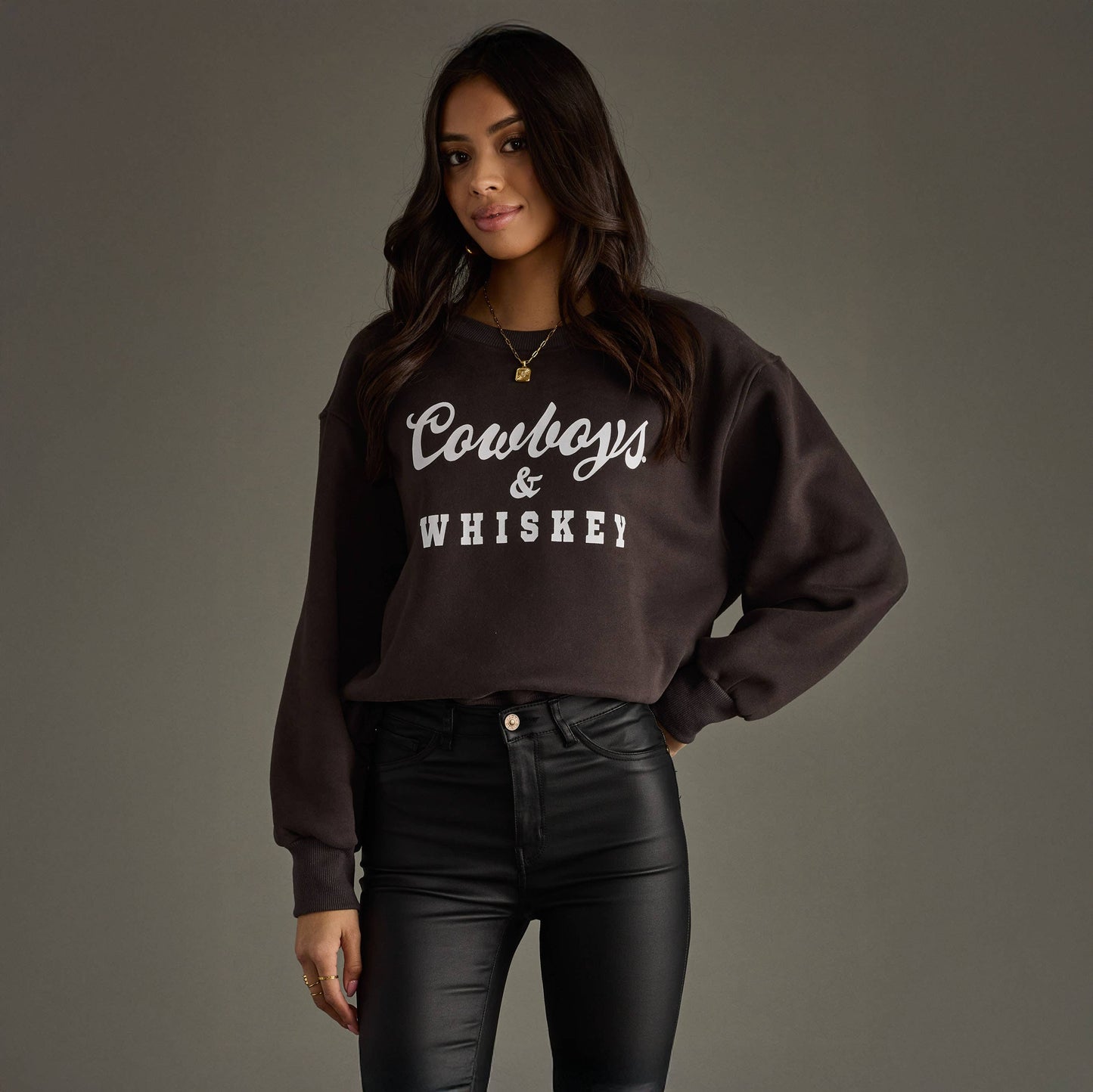 Woman wearing sweatshirt that says Cowboys & Whiskey.