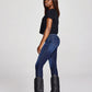 Woman in black top, blue jeans, and black boots.