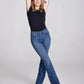 Woman in black top and jeans, posing.