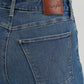 Close-up of blue jeans with a Wrangler leather patch.