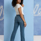 Woman in jeans and white top, standing.