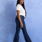 Woman in white top and jeans walking.