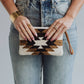 Woman holding patterned clutch.