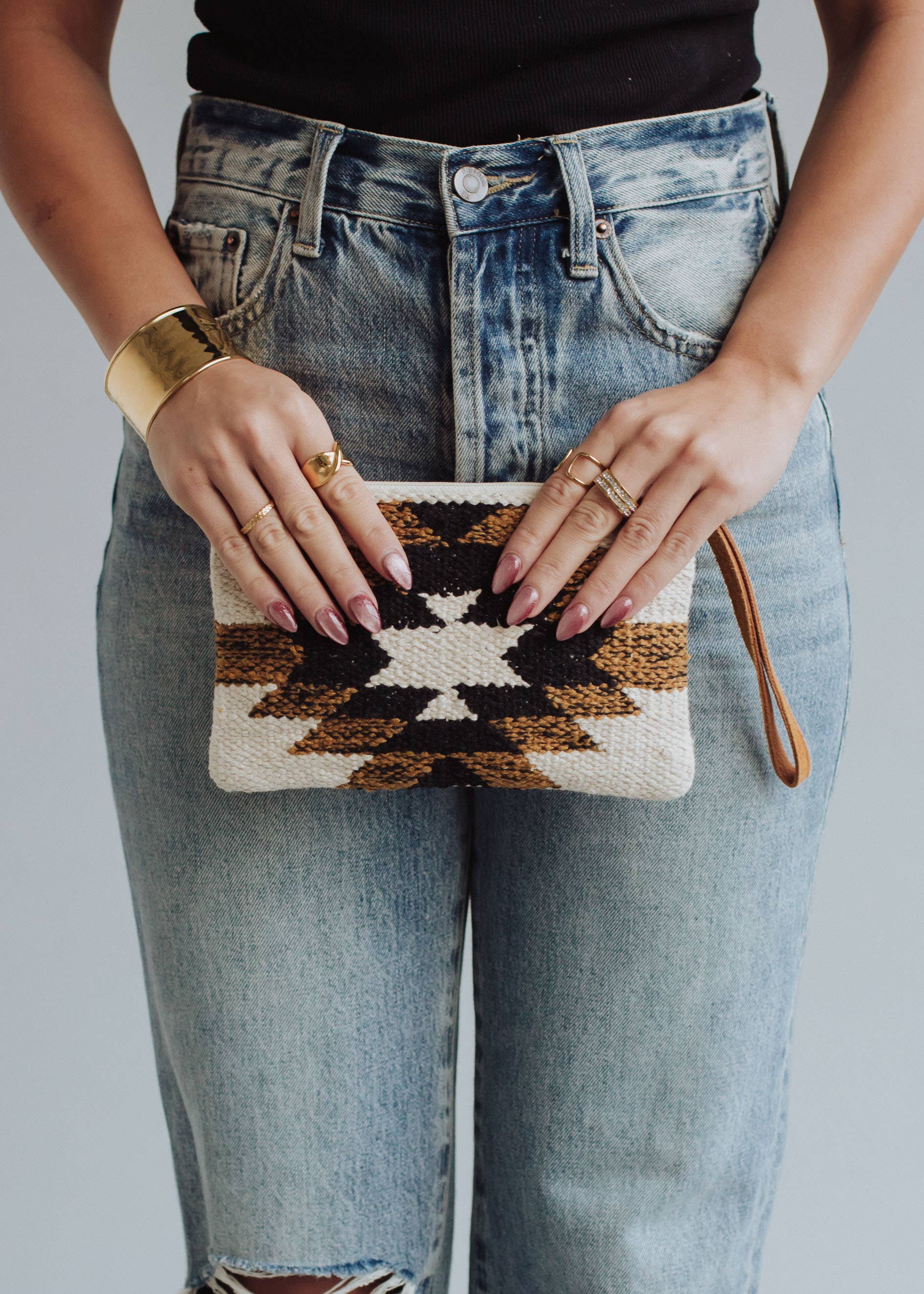 Woman holding patterned clutch.