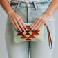 Woman holding a patterned clutch purse.