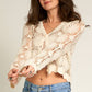 Woman in crochet cardigan and jeans.