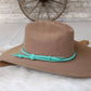 Brown cowboy hat with turquoise band.