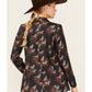 Woman in a black blazer with horse print, wearing a cowboy hat.