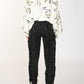 Woman in patterned shirt and black pants.