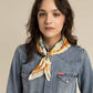 FW23 Studio Model wearing patterned scarf and denim shirt.