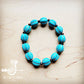 Turquoise beaded bracelet on wood surface.