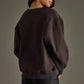 Woman wearing dark sweatshirt and black pants.