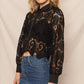 Woman in black lace jacket and denim skirt.