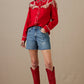 Woman in red rodeo top and denim shorts