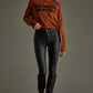Woman wearing brown sweater and black pants.