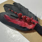 Black feather with red and black beads and red feather.