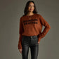 Woman in sweater and black pants.