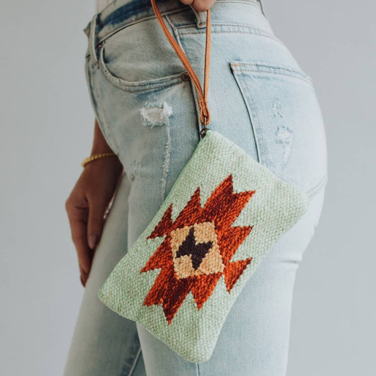 Woman holding a patterned clutch purse.