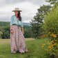 Toni Shirt & Sunny Skirt outfit on a woman in a field.