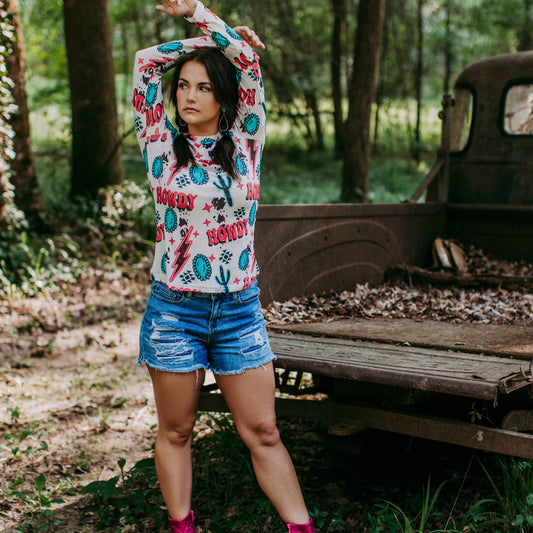 Woman in shorts and printed shirt near truck.