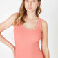 Woman wearing a coral-colored tank top.