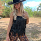 Woman in fringe top and leopard pants, cowboy hat