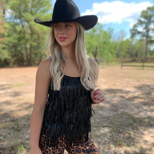 Woman in black fringe top and cowboy hat